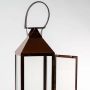 Closeup of brown metal lantern showing clear glass sides and openable door for elegant decorative accent lighting.