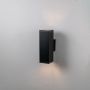 Black rectangular wall light glowing on white background showcasing simple structure and smooth matte finish.