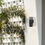 Contemporary black wall light enhancing minimalist exterior decor with warm balanced glow.