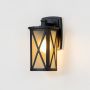 Black metal outdoor lantern with frosted glass shown with light on against a white background highlighting warm soft illumination and modern X frame.