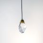 Closeup of faceted crystal pendant lamp with golden holder showing fine detailing and modern craftsmanship.