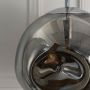 Closeup of smoky grey glass globe pendant lamp highlighting reflective surface and elegant bulb detail.