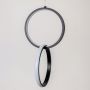 Closeup of modern metal dual ring hanging light in black and white highlighting smooth finish and stylish wall decor design.