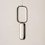 Black and white metal dual frame hanging light glowing gently on white background for stylish contemporary wall decor.