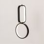Black and white metal dual shape hanging light glowing softly on white background for stylish contemporary wall decor.