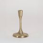 Modern gold candle holder with minimal design shown in room setting without white background for natural ambiance