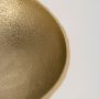 Close view of gold bowl showing detailed hammered interior and sculpted metal base with reflective textured finish