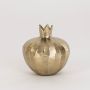 Gold pomegranate decorative accent shown on a clean white backdrop with focus on its crown top and carved detailing