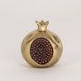 Golden pomegranate decor shown on a clean white background with focus on its textured seed detailing
