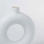Closeup of white ceramic donut vase highlighting its smooth matte finish rounded edges and sculptural hollow center perfect for elegant modern decor accents.