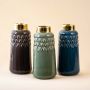 Three tall ceramic vases in dark grey green and navy blue with gold rims standing together on a beige background showcasing their glossy finish and geometric texture in a clean grouped display.