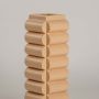 A detailed closeup of the beige geometric vase showing its rounded stacked pattern and smooth finish highlighting its modern artistic design.