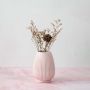 Stylish pink ceramic vase enhancing modern living room decor adding a soft pastel accent to the neutral setting.