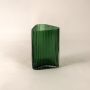 Side angle view of ribbed green glass vase showing curved top and textured surface adding elegance to contemporary decor settings.