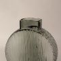 Closeup of smoky gray round glass vase highlighting its intricate wavy pattern and elegant matte glass finish.