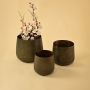 Brown metal planter decor paired with matching pieces creating a rustic modern accent for shelves and living room spaces.