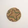 A handwoven teal mustard and natural rattan decor plate shown on a clean white background highlighting its sun inspired circular weave for colorful modern wall styling.