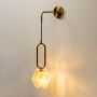 Elegant gold and glass wall sconce glowing against white background ideal for bedroom or hallway lighting decor.
