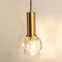 Closeup view of gold hanging wall sconce highlighting its faceted glass shade curved metal arm and warm lighting design perfect for modern interior home decor.