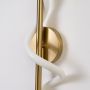 Closeup of gold metal wall light with white spiral tube showing smooth detailing and premium contemporary design.