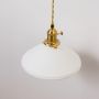 Closeup of gold metal wall light with white ribbed shade showing fine detailing and premium classic lighting design.