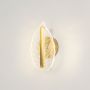 Gold metal and clear glass leaf wall light glowing gently on a clean white background for elegant modern home lighting.