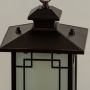 Closeup of black hanging lantern showing frosted glass glow geometric panel detailing and classic top design perfect for porch and entryway lighting.