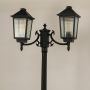 Closeup of black metal dual lantern lamp post showing ribbed glass panels and elegant curved arms perfect for outdoor pathway garden and porch Decor.