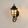 Black metal outdoor wall lantern light on featuring frosted glass shade and curved arm design ideal for porch patio balcony and entryway exterior lighting Decor.