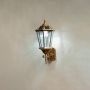 Antique gold outdoor wall lantern displayed on a white background highlighting its clear glass panels and decorative vintage frame.