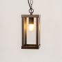 Rectangular brown metal lantern light glowing warmly on white background with clear glass panels.
