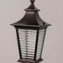 Close view of black metal outdoor lantern showing ribbed glass panels and warm bulb for stylish exterior lighting decor.