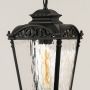 Closeup of black hanging lantern showing the textured clear glass panels decorative metal top and vintage frame ideal for enhancing porch and entry lighting decor.