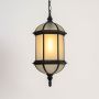 A decorative outdoor hanging lantern light turned on displayed against a white background highlighting its metal frame frosted glass panels and vintage inspired design.