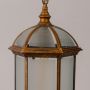 Closeup view of the antique hanging lantern showing detailed metalwork and frosted glass panels with a clear focus on texture and craftsmanship.