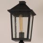 Closeup of black outdoor lamppost showing textured lantern frame and clear glass panels for elegant classic exterior lighting.