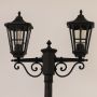 Closeup of black outdoor lamppost showing ornate metal detailing and clear glass lanterns for elegant vintage exterior lighting.