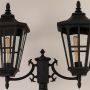 Closeup of black metal outdoor street lamp showcasing detailed lantern design for classic exterior lighting.