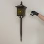 Brown solar garden spike lantern with patterned glass shown with light off on a white background showcasing its elegant frame and tall spike structure.