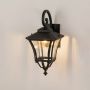 Black metal outdoor wall lantern glowing softly with clear glass panels for bright entryway and garden lighting.