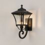 Black metal outdoor wall lantern glowing through textured glass ideal for entryway and exterior home lighting.