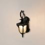 Black outdoor wall lantern glowing softly with frosted glass shade perfect for entrance and patio wall lighting.