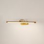 Gold metal picture light glowing with warm illumination on a clean white background ideal for modern wall lighting.