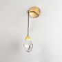 Gold wall light with crystal detail switched off on white background for minimalist modern bedroom wall lighting.